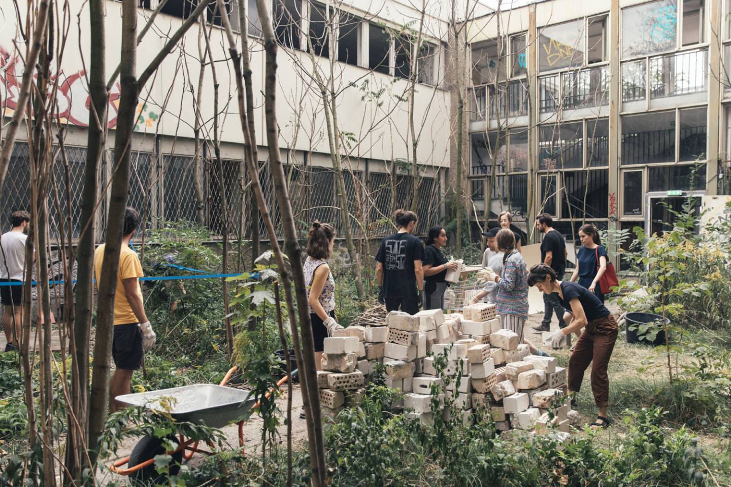 A group of people building with bricks in a backyard.