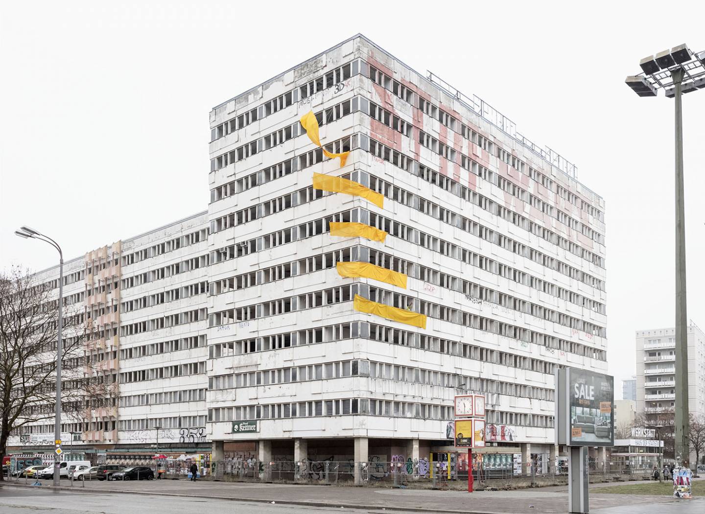 Big GDR building with Stop Wars sign and yellow flags.