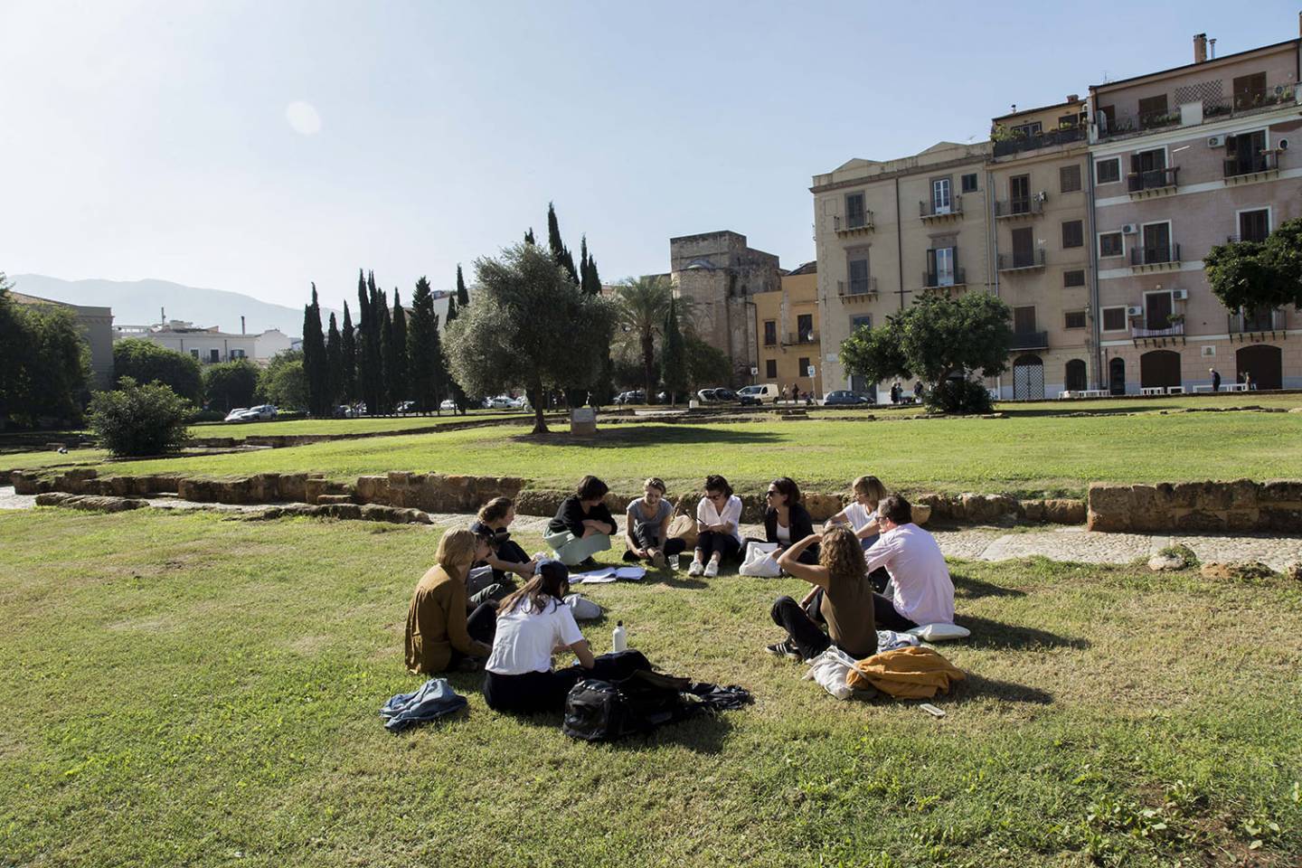 People sitting on the grass in a circle.